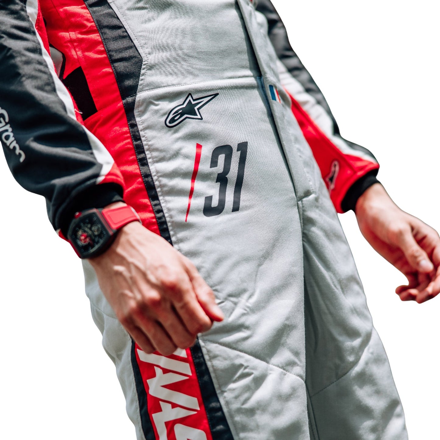 Close-up of an Esteban Ocon wearing a 2025 Haas F1 200th Race Look Canadian GP racing suit with visible branding - Kartx Gear