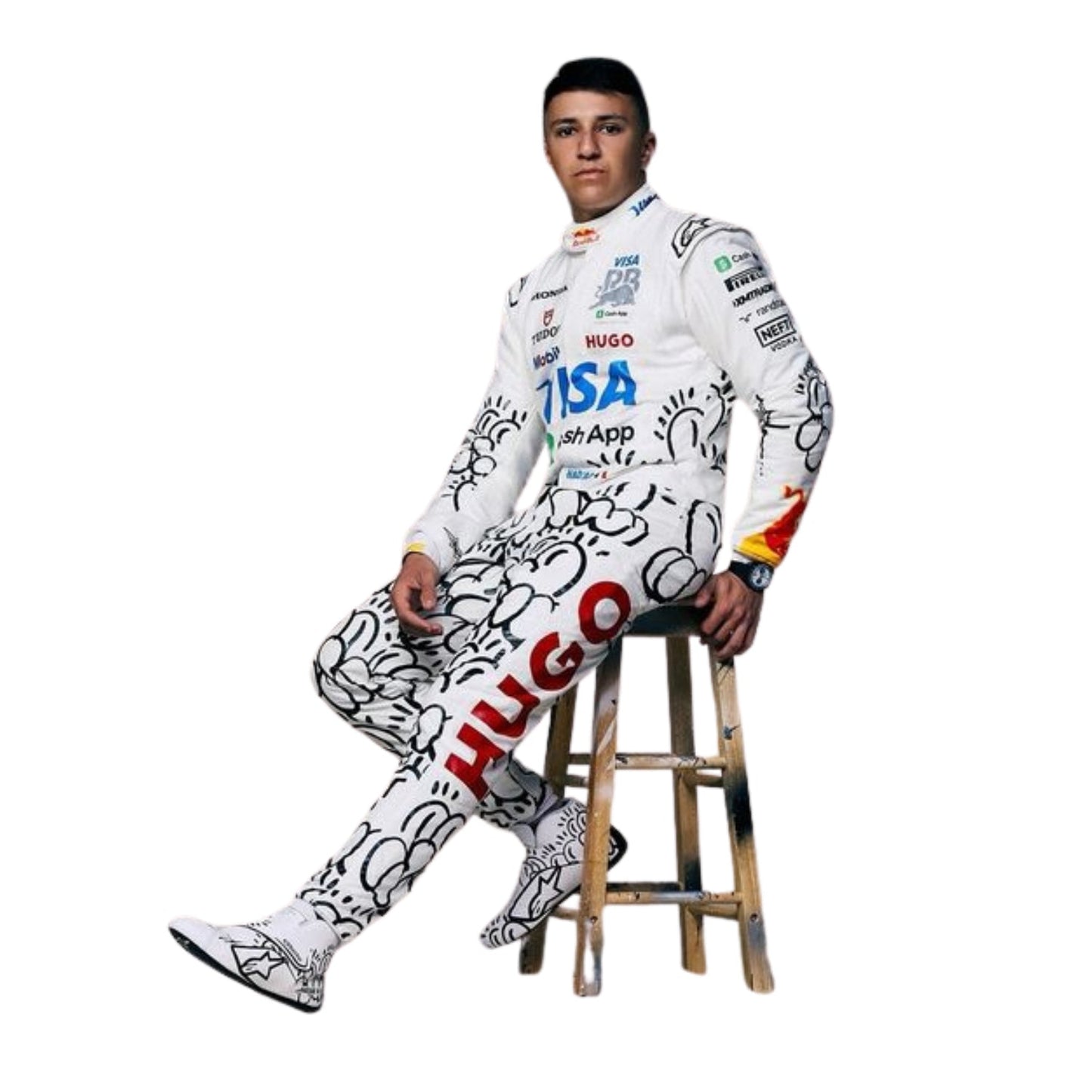 Isack Hadjar is wearing a 2025 VCARB British GP F1 racing suit with various logos, sitting on a wooden stool - Kartx Gear