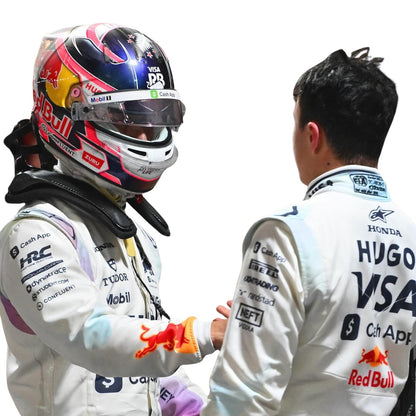 Two Formula 1 drivers, Isack Hadjar and Liam Lawson, are shaking hands, one wearing a helmet with visible branding - Kartx Gear