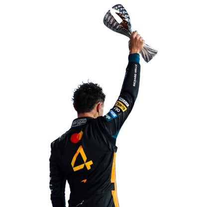 Lando Norris, Team F1 McLaren, Abu Dhabi GP, wearing a 2025 F1 racing suit, holding a trophy against - Kartx Gear