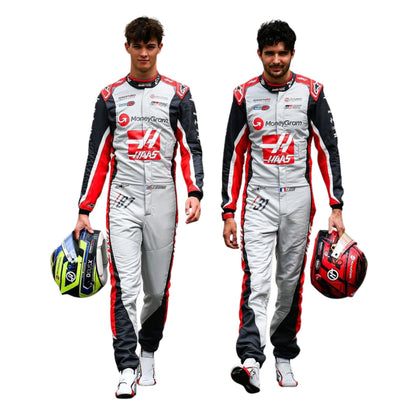 Two individuals, Esteban Ocon and Oliver Bearman, wearing a 2025 Haas F1 200th Race Look Canadian GP racing suit with helmets - Kartx Gear