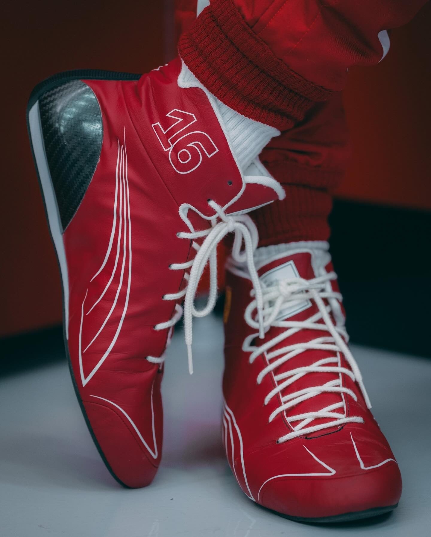 Red high-top 2025 Charles Leclerc Ferrari F1 Racing sneakers with white laces and a number 16 on a neutral background - Kartx Gear