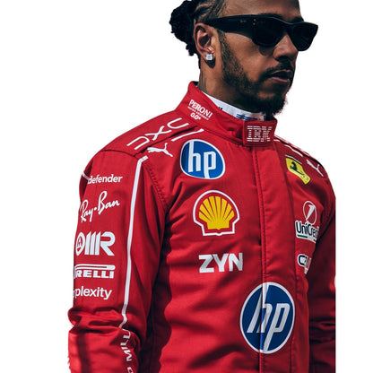 A Lewis Hamilton wearing a red Ferrari racing suit with multiple sponsor logos, black sunglasses, and a beard, shown against a plain white background.