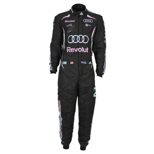 A black racing one-piece suit with pink and light blue accents, featuring prominent Audi and Revolut sponsor logos, Adidas branding, and signatures on the chest, displayed against a solid white background.